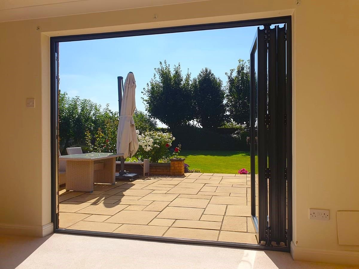 Bifold doors folded back onto a sunny patio