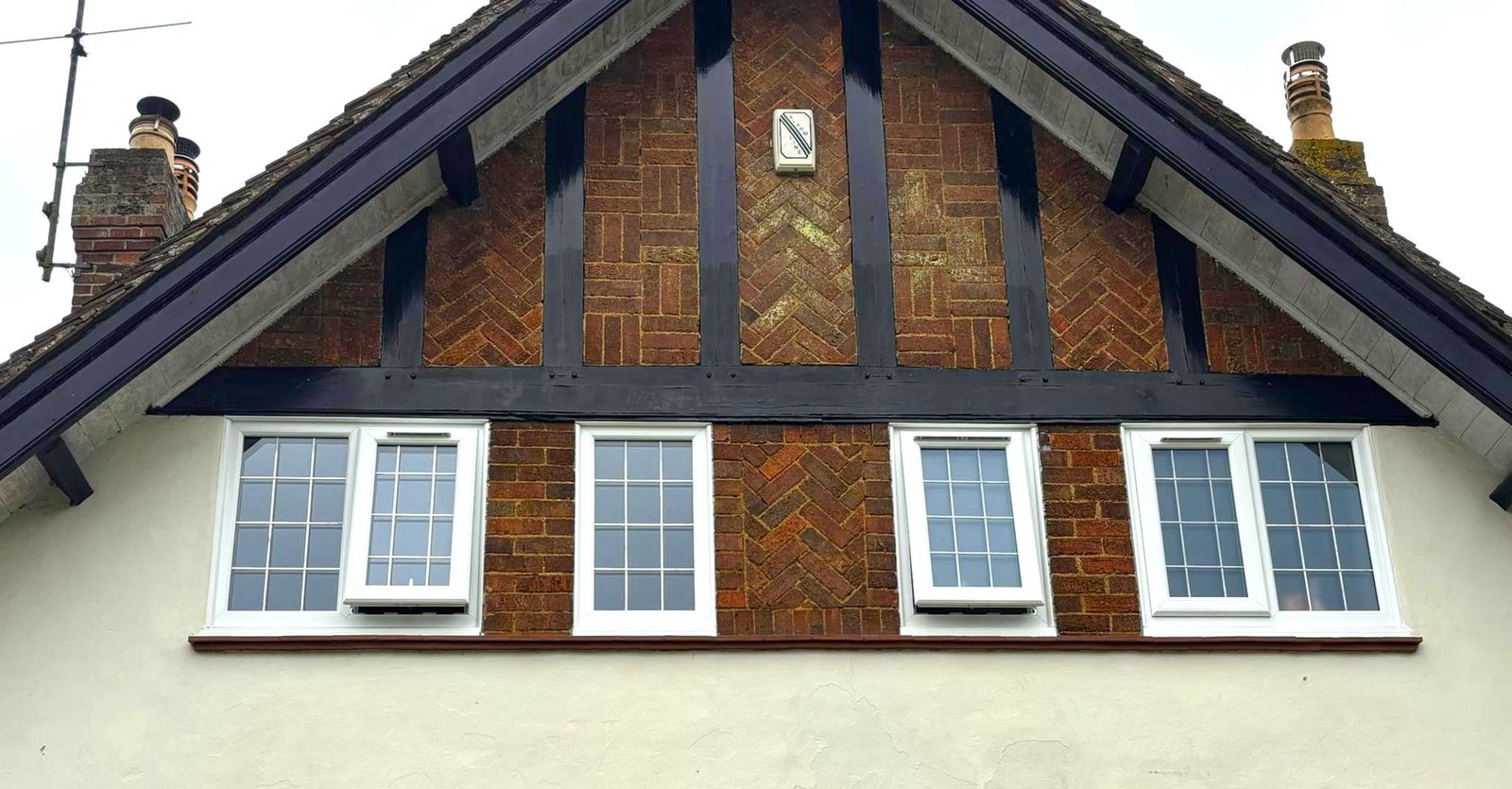 A row of white windows under a timbered gable