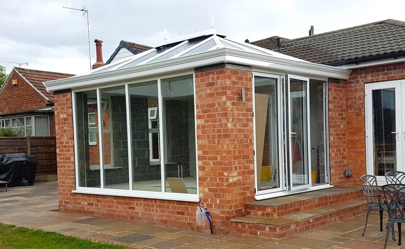 A conservatory on a brick base seen from the garden