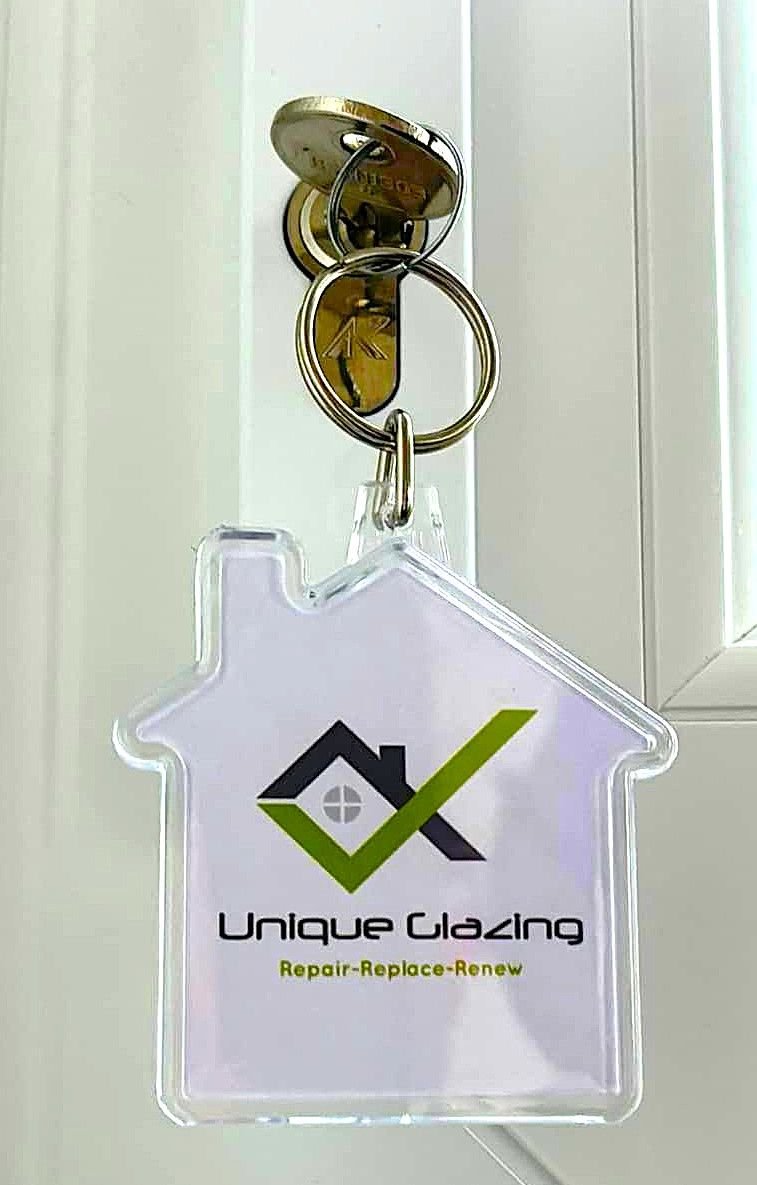 A Unique Glazing key ring hanging from a key in a new door