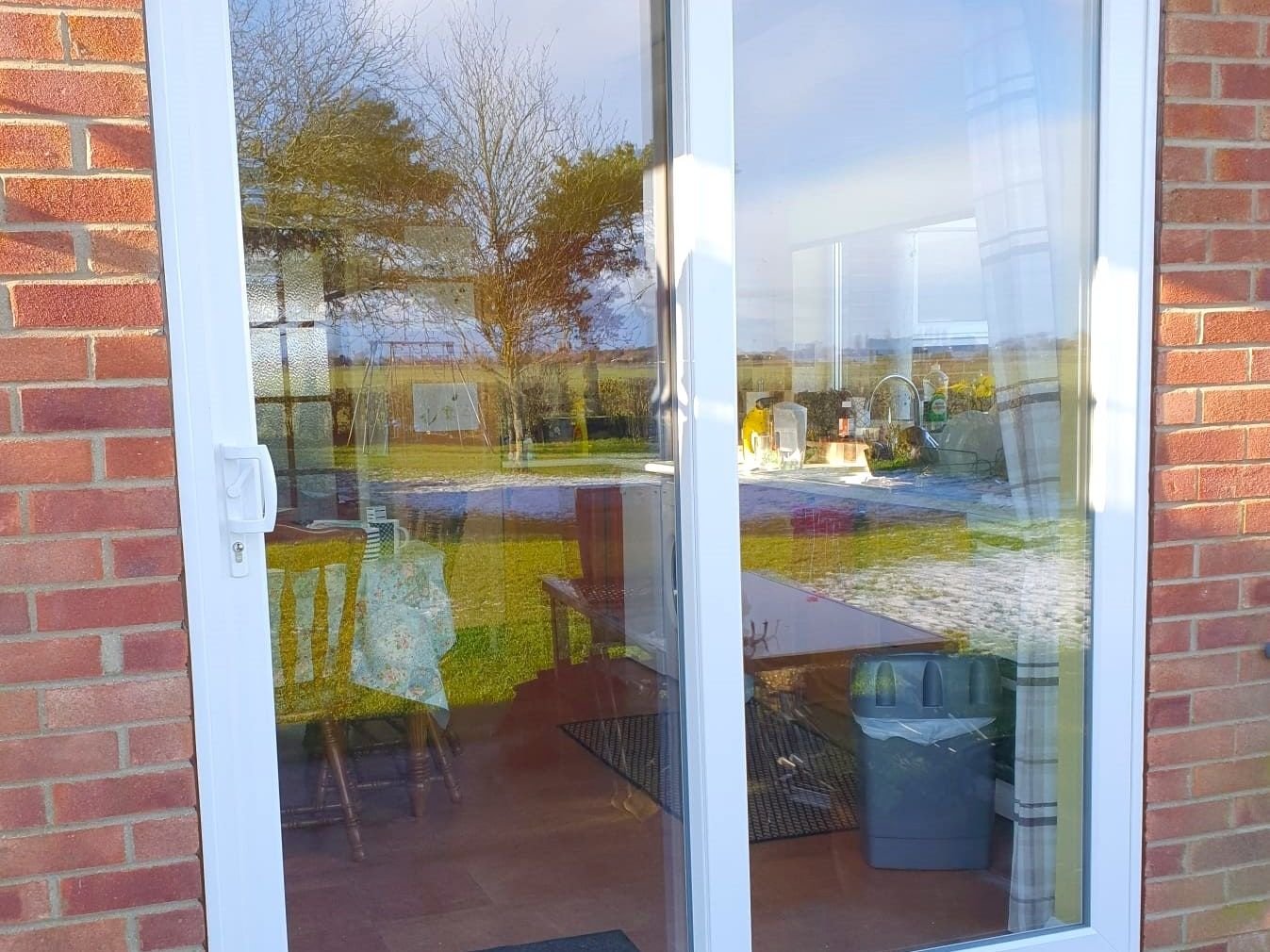 White sliding patio doors in a red brick wall