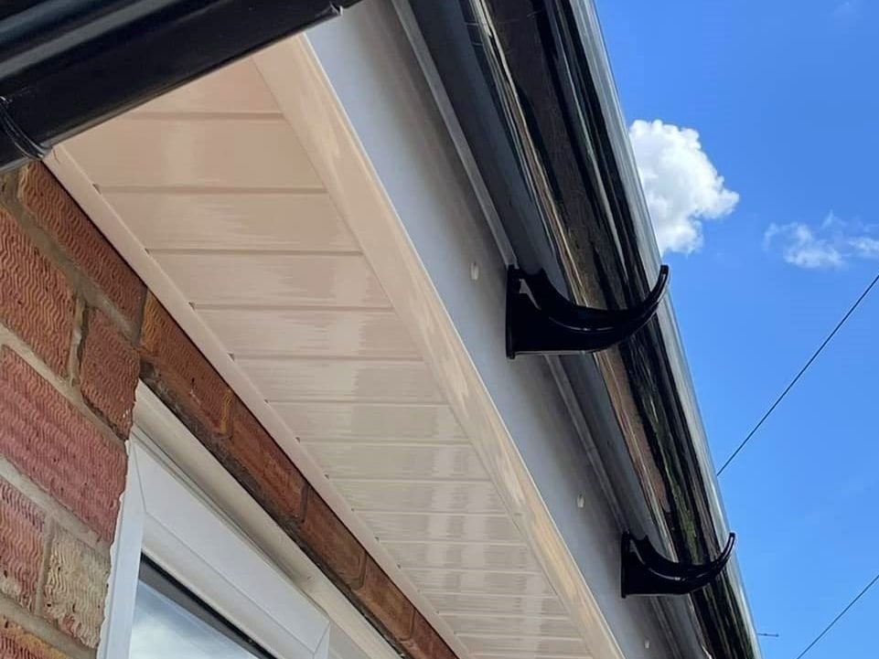 New black guttering and white soffits on a brick house