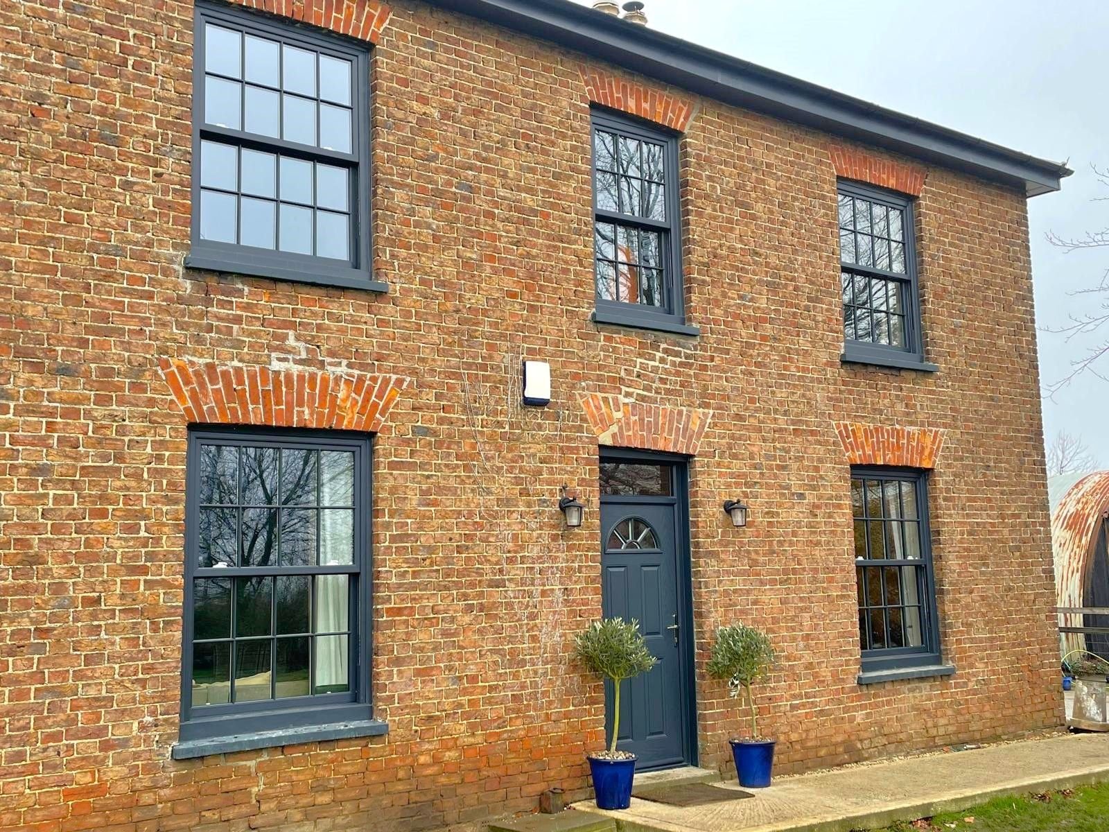 Grey sash windows on a red brick house