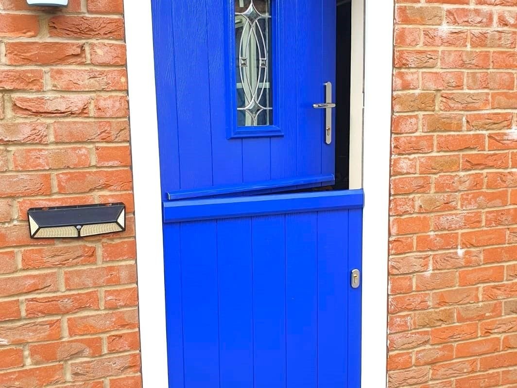 A blue stable door in a red brick wall