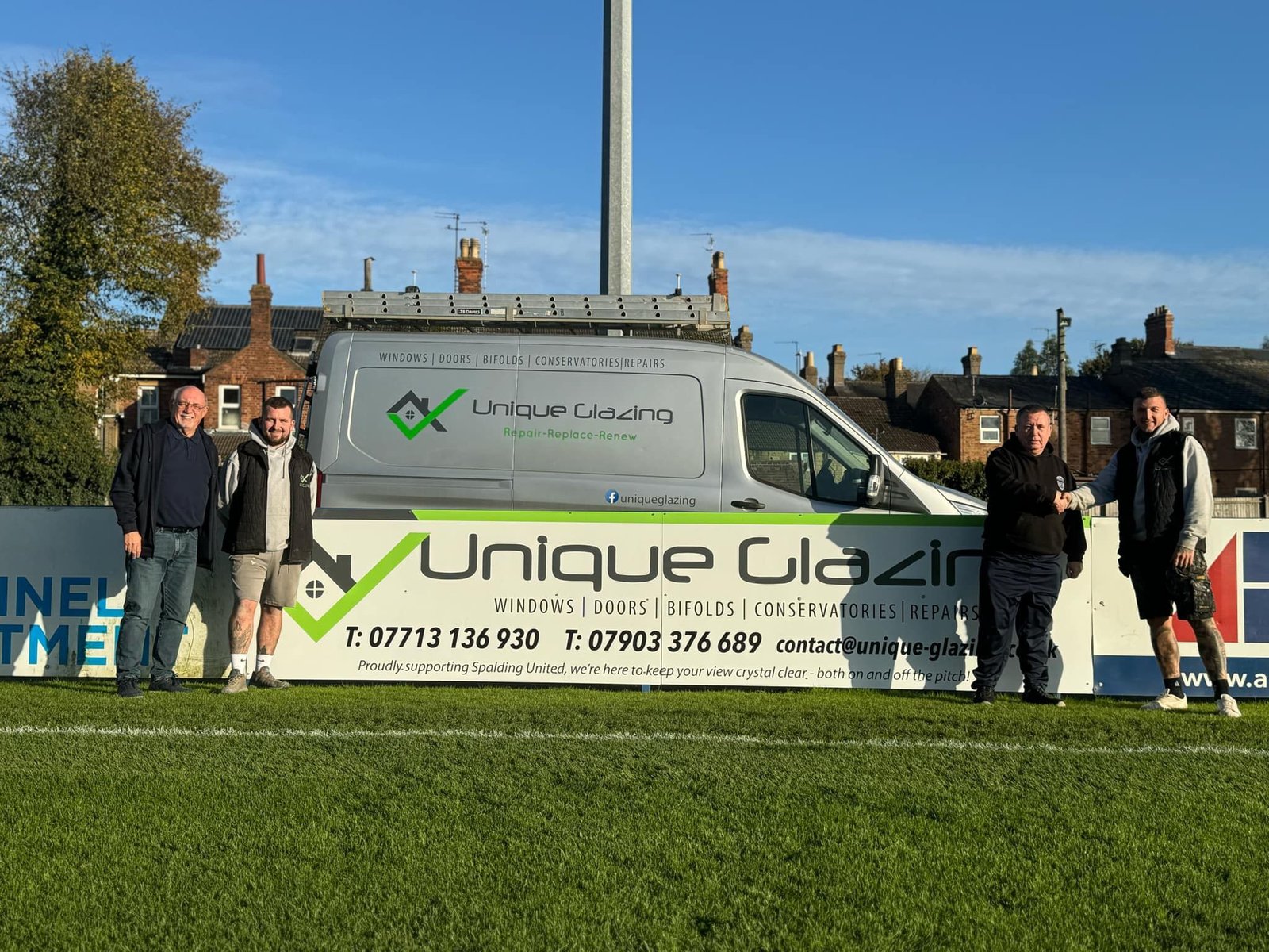 The Unique Glazing team with their van beside their sponsor board at Spalding United
