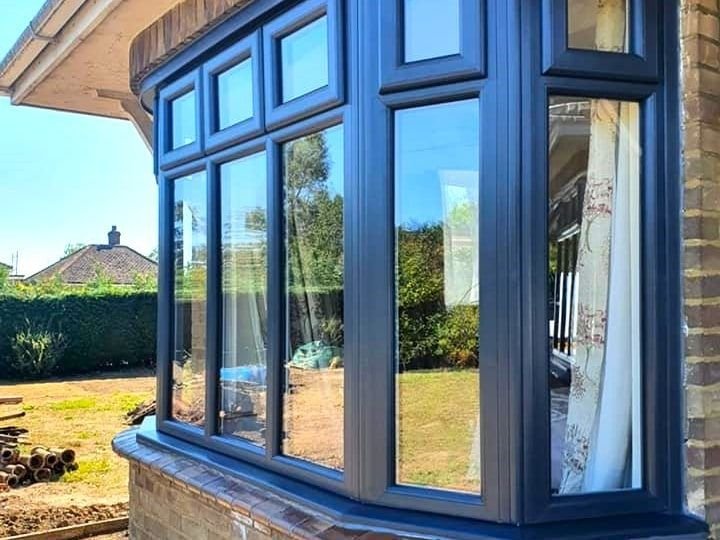 Dark blue flush casement windows around a curved bay